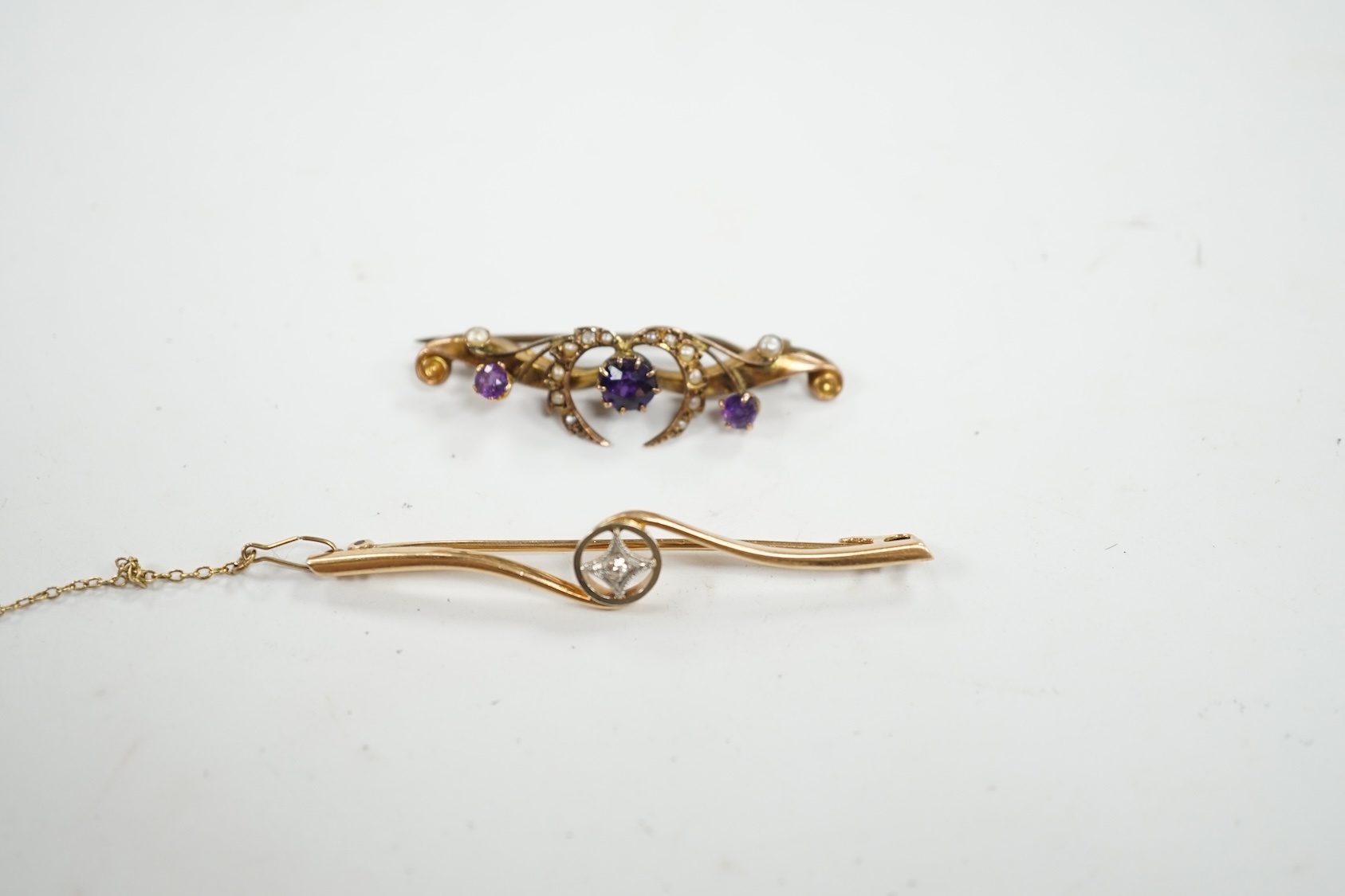 An Edwardian 15ct and diamond set crossover bar brooch, 57mm, gross weight 3.9 grams, together with a similar 9ct gold, amethyst and seed pearl set bar brooch, gross weight 2.3 grams. Condition - fair